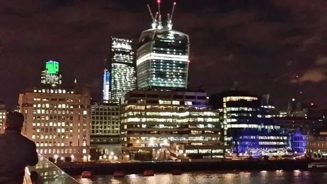 London office towers lit up at night along the river