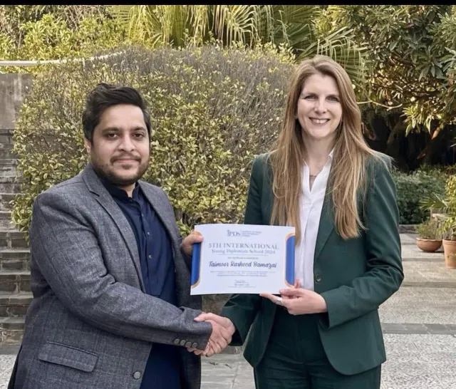 Taimoor Bamazai shaking hands and holding a certificate from the 5th International Young Diplomats School 2024
