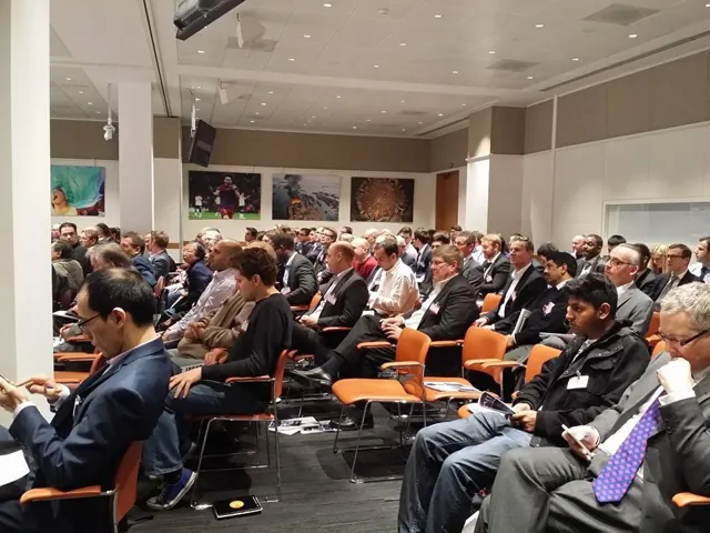 A seminar room full of attendees in business dress